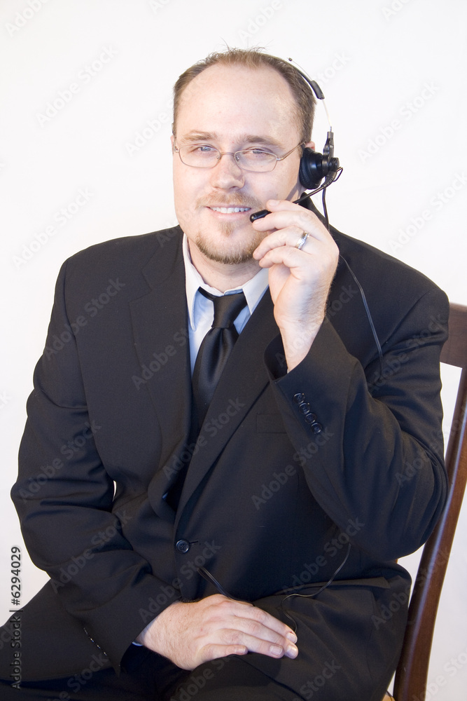 Young business man with headset talking on phone Young business man with headset talking on phone