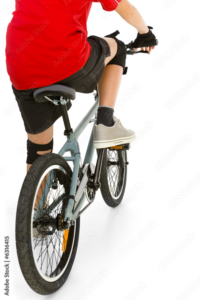 Fototapeta premium Young boy in red T-shirt cycling on BMX . Rear view.