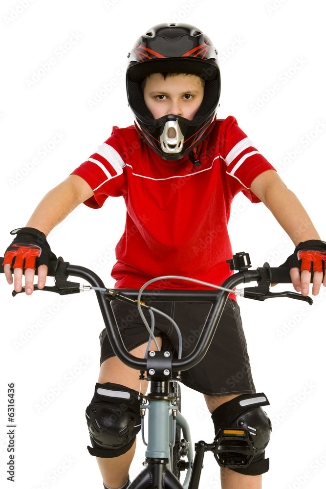 Young boy in helmet and protection kit sitting on BMX 