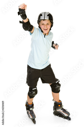 Young, happy roller boy in protection kit standing with hand up