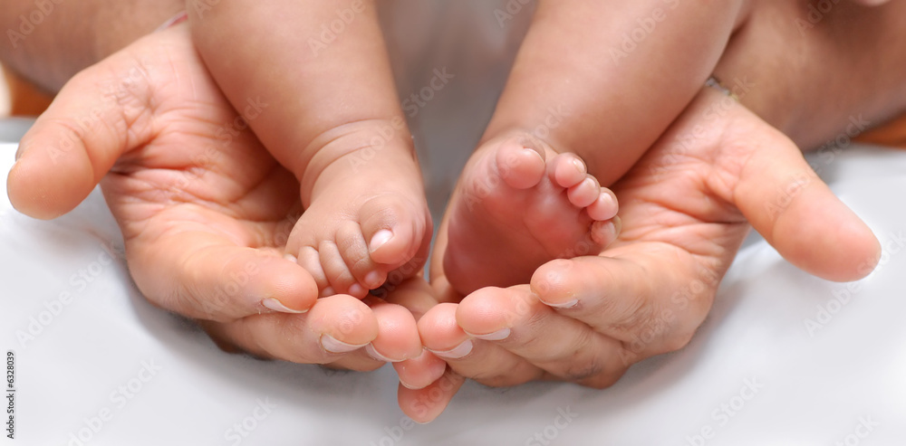 close up of a father's hand cradling babies feet - obrazy, fototapety, plakaty 