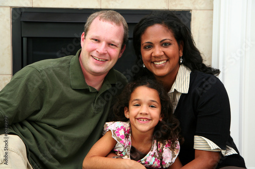 Interracial family sitting together at home