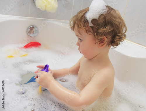 A child playing with toys in a bathtub.