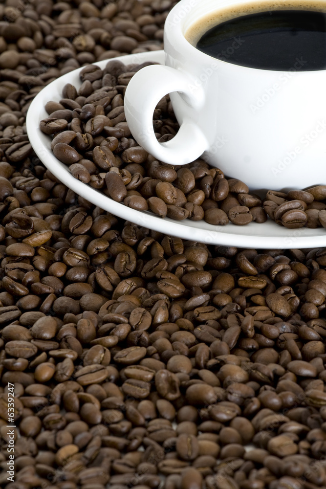 Fototapeta premium Cup of coffee view from above and coffee beans background