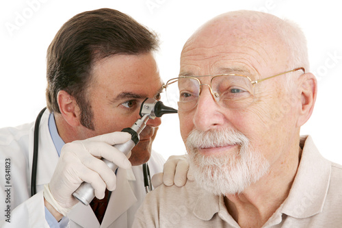 Doctor using otoscope to look in a senior man's ears.   photo