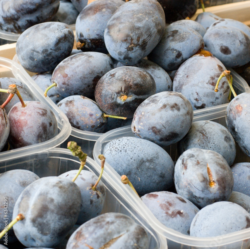 A fruit stand with plums for sale.