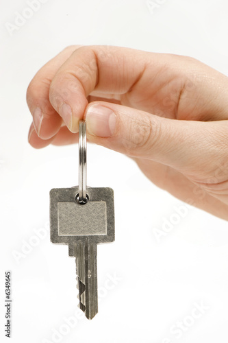 close up of a person's hand handing over the key. 