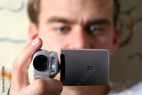 young man with digital video camera © art_of_line