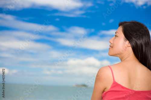 side view of a red tank top woman with blue sky