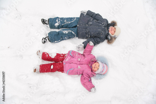 two children lie on snow