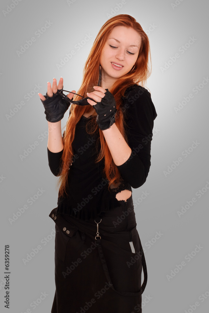 beauty redhead girl in black clothes with sunglasses