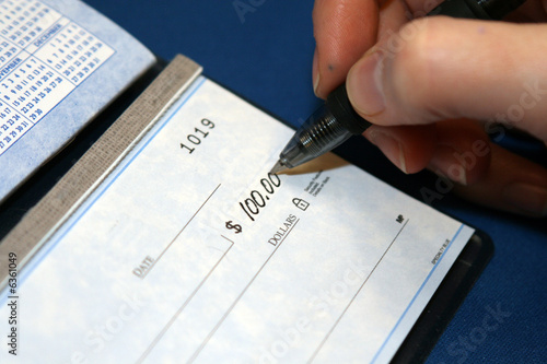 A closeup of a person writing a personal Check