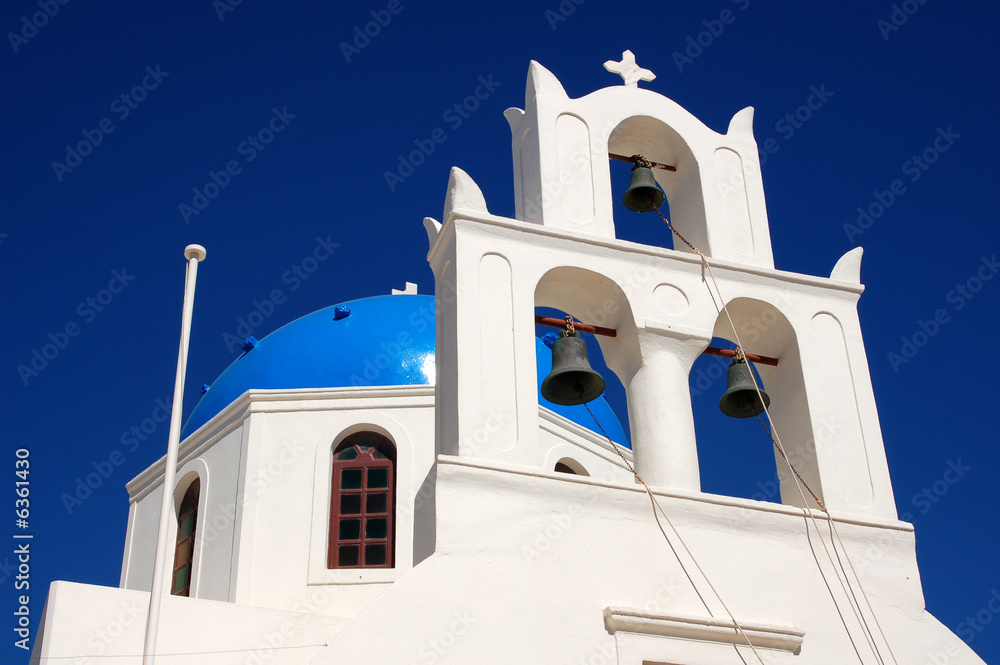 The church bells and blue dome of a greek building.