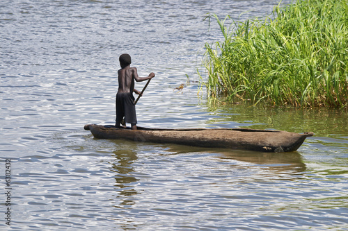 A young boy dugout canoe in Lake Malawi