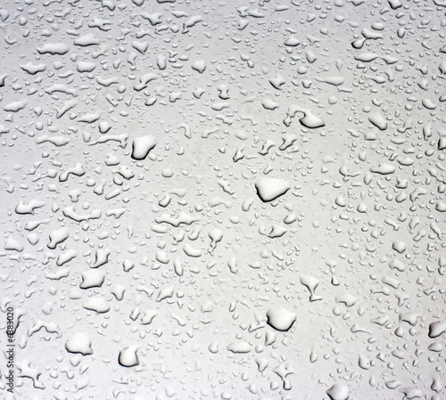 Rain droplets on a grey metallic surface