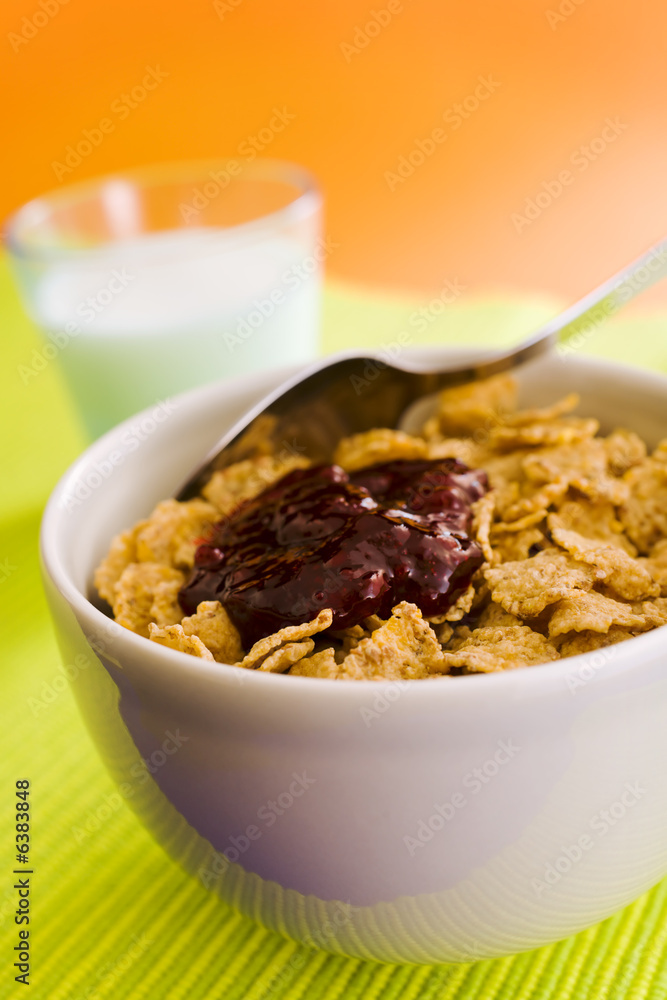 Corn flakes on the vase with jam and spoon Corn flakes on the vase with jam and spoon