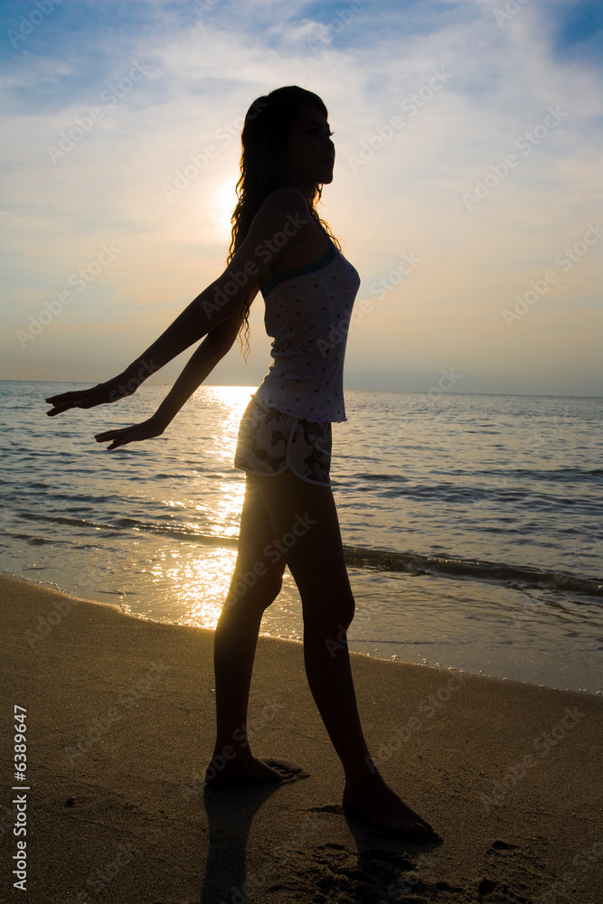 Fototapeta premium silhoette of a woman doing stretching exercise at sunset