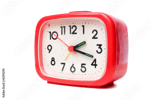 Old red alarm clock on a white background