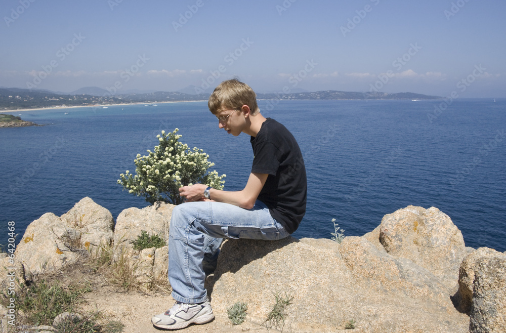 teen sitting on rocks
