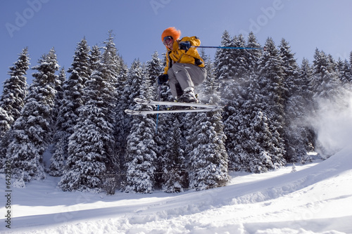 Snow Skier Jumping in the winter forest in mountains 