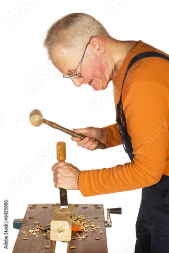 carpenter is chiseling and carving the wood