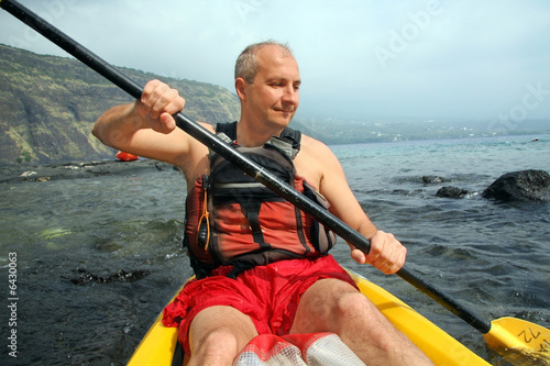 Mature man kayaking in the ocean on Big Island, Hawaii