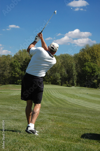 Golfer in the after swing looking on a beautiful sunny day