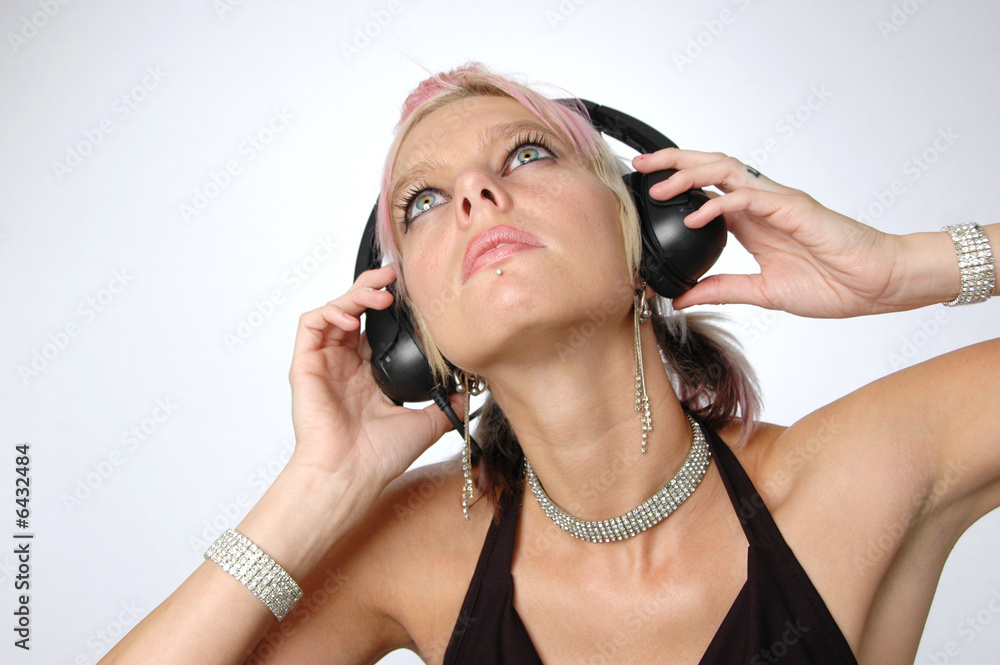 Fototapeta premium Blond enjoying music with headphones on a neutral background