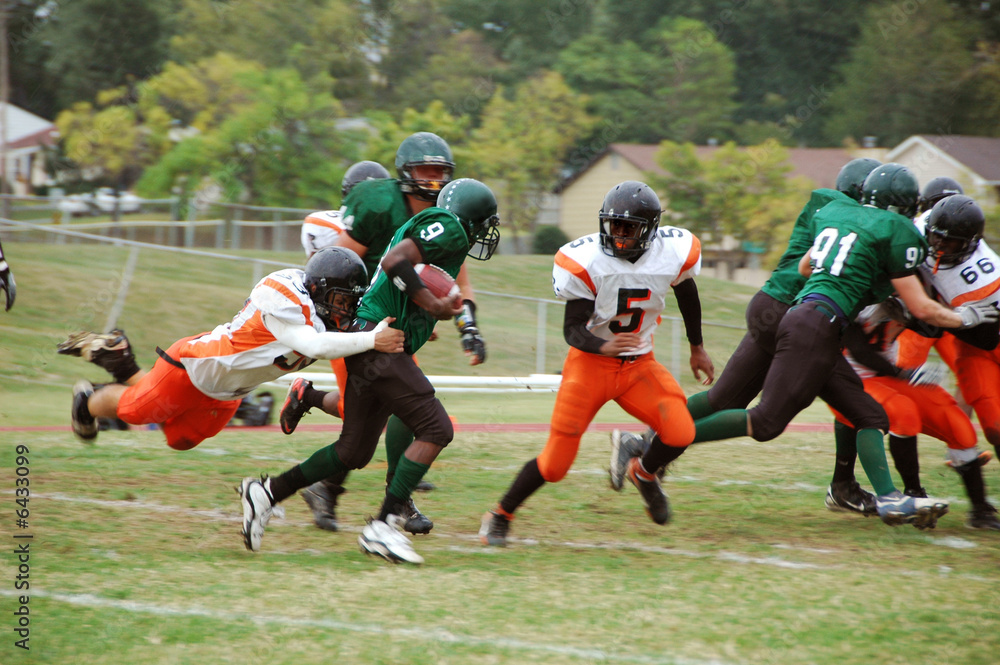 Running back american football player being tacked Running back american football player being tacked