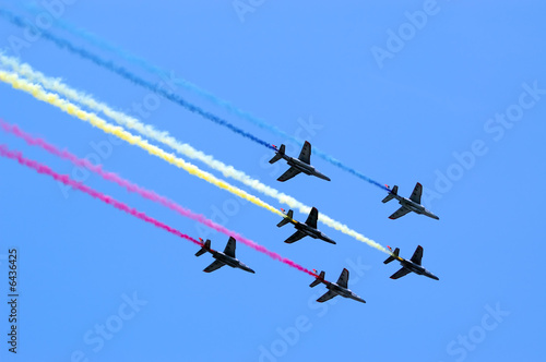Six aircrafts in the blue sky making colour smoke