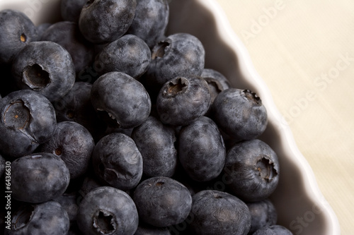 a white cup full of fresh ripe blueberries