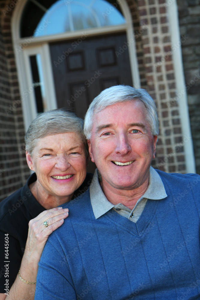 Happy Senior Couple smiling outside in front of their house Happy Senior Couple smiling outside in front of their house