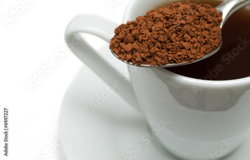 Closeup of instant coffee granules in silver spoon 