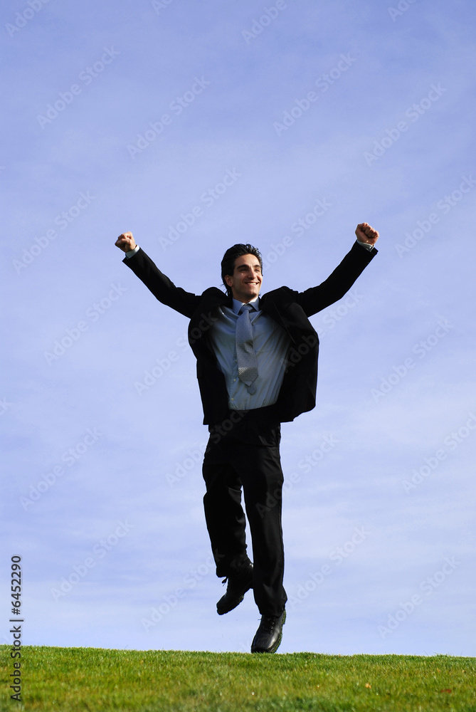 successful and happy young adult businessman jumping successful and happy young adult businessman jumping