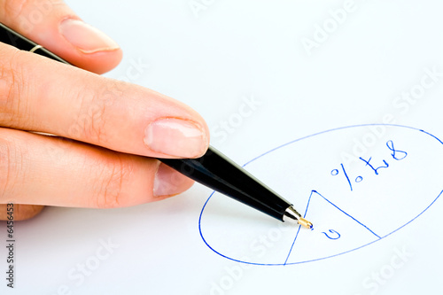 Closeup of human hand holding a pen and drawing diagram 