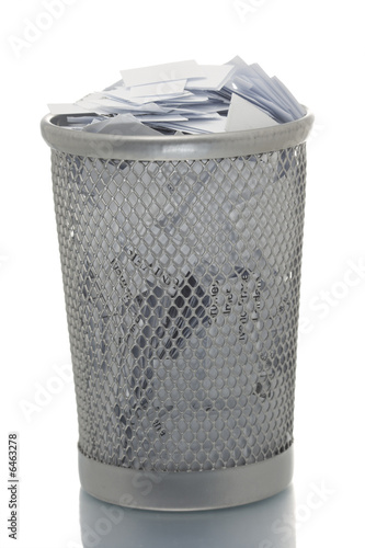 Mesh trash bin full of small paper pieces
