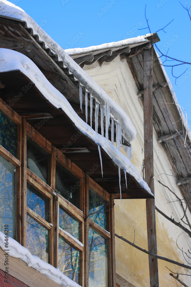 Nice winter ice snow background. Winter icicles hanging from eaves of roof. 