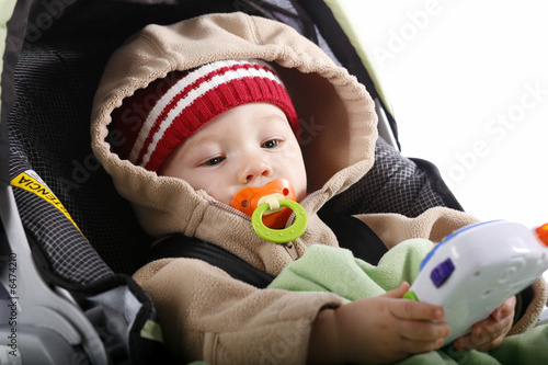 Baby with toy in car seat