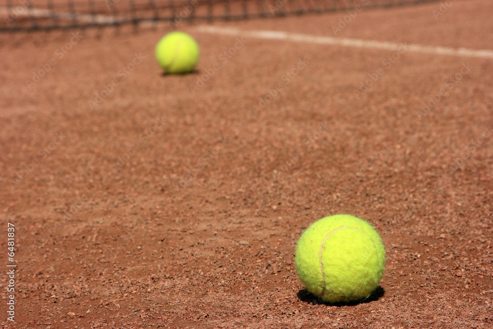 Two tennis balls on a tennis field