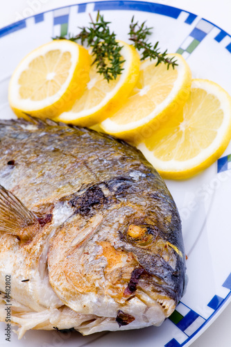 Gebratener Fisch auf Teller mit Zitrone