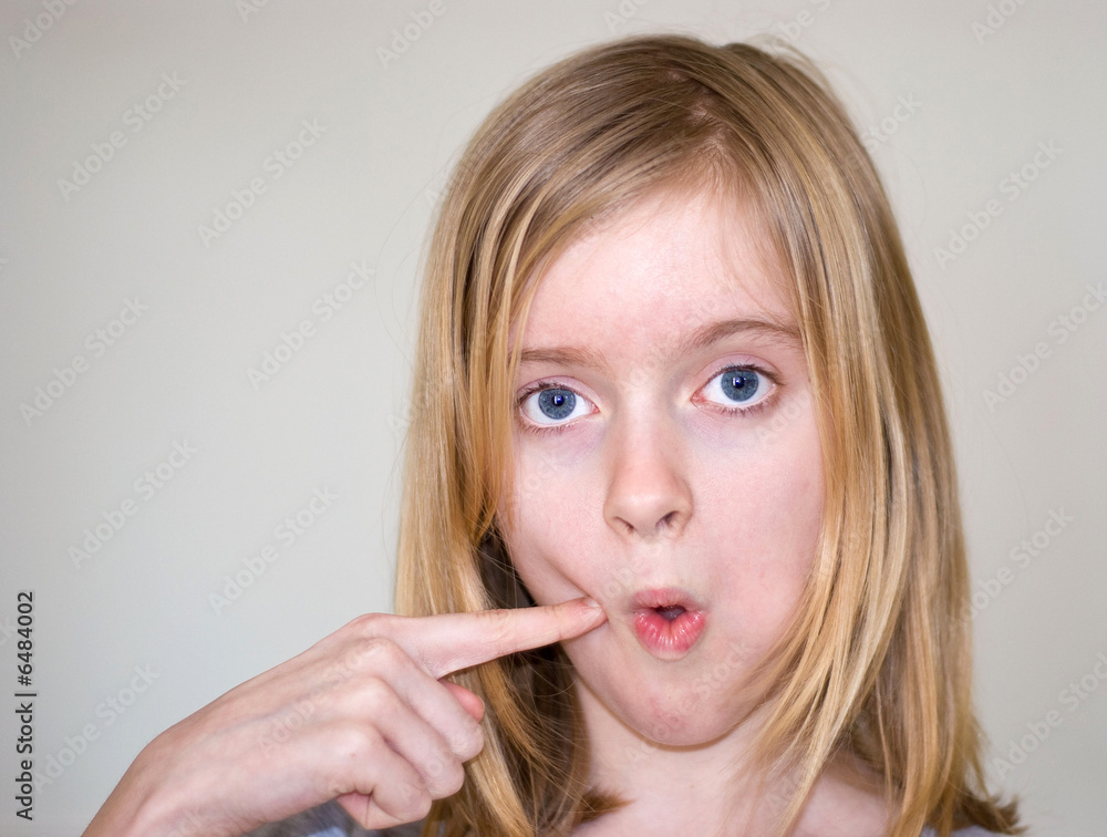 11 year old blond girl making face, finger in cheek Stock Photo | Adobe ...