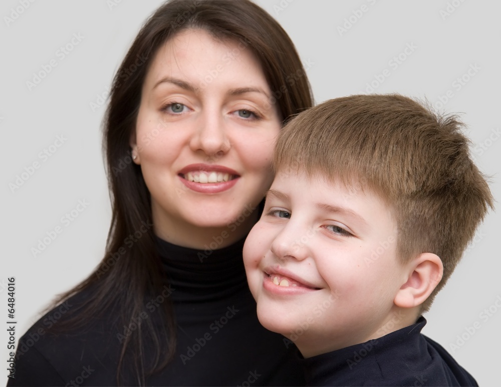 Smiling family. Mum and the son on a grey background. Smiling family. Mum and the son on a grey background.