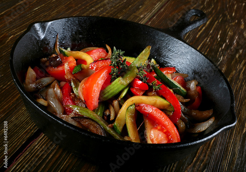 Fried vegetable with spice in black pan photo
