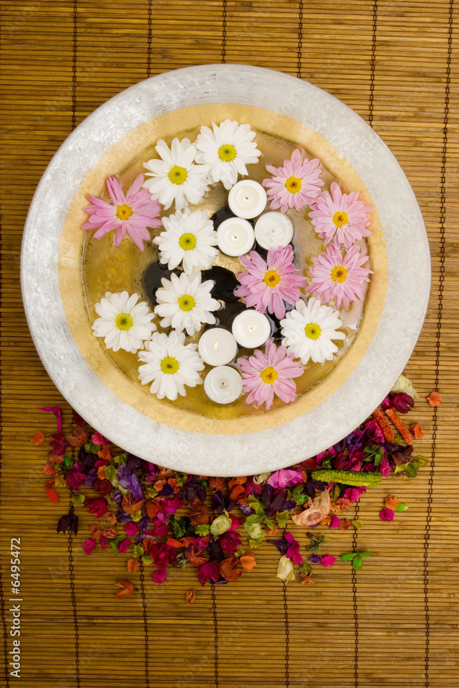 White daisies and spa candles in water
