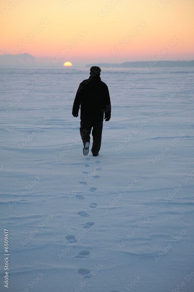 Fototapeta premium man goes through the snowy field 2