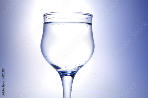 Nice goblet with drink and blebs on white-blue background