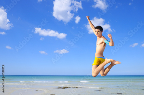 Boy jumping on tropical beach