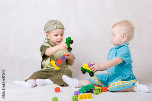 a boy and a girl of one and a half years old play the designer c