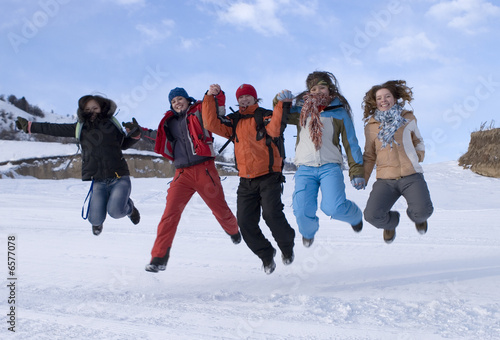 Group of sports teenagers jumping in mountains, over blue sky