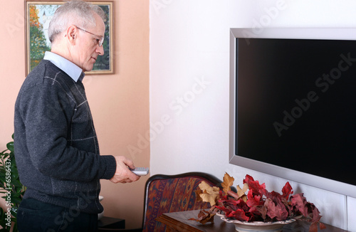 Man with a remote turning on the TV